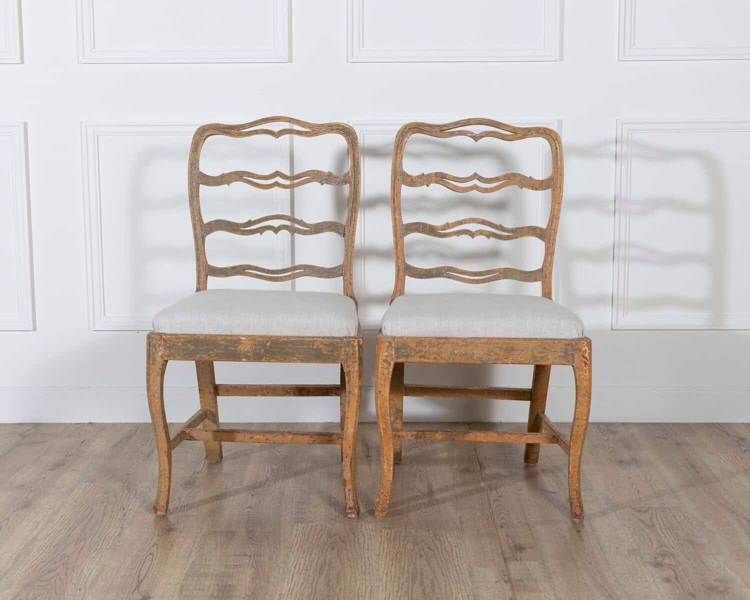 A pair of slender Gustavian chairs with smiling details, scraped to original paint and newly covered in linen. Circa 1780 - JAA