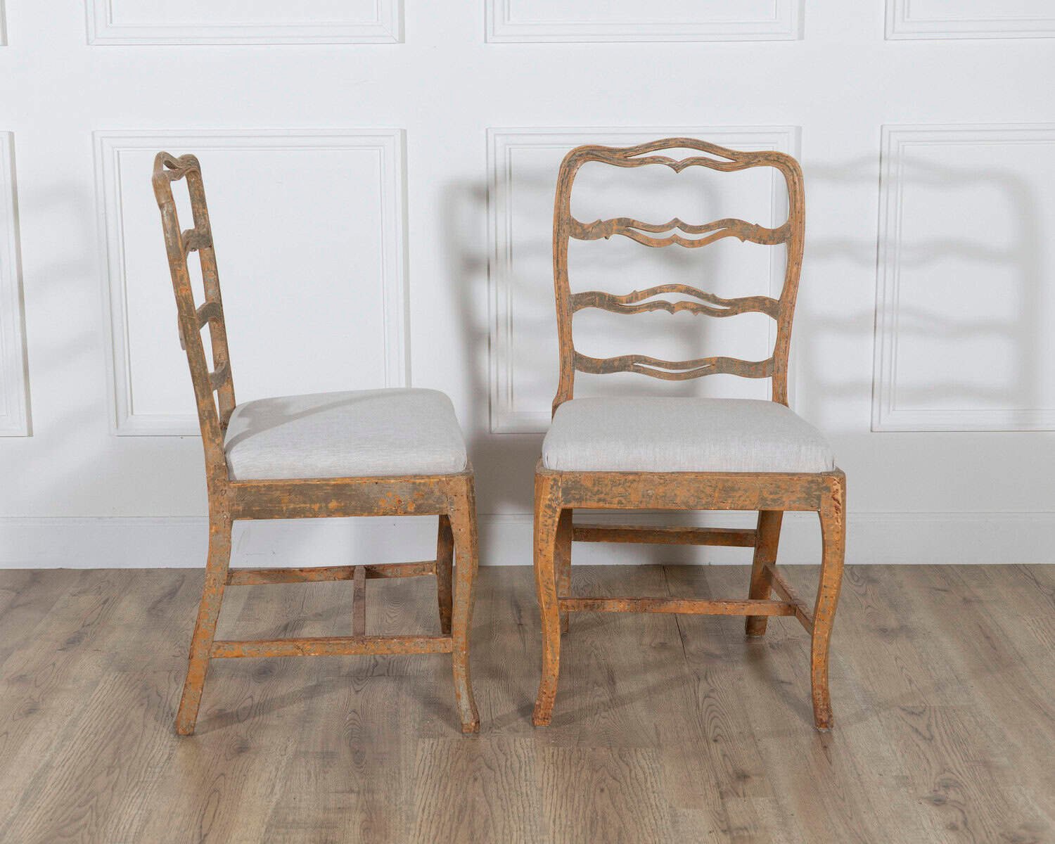 A pair of slender Gustavian chairs with smiling details, scraped to original paint and newly covered in linen. Circa 1780 - JAA