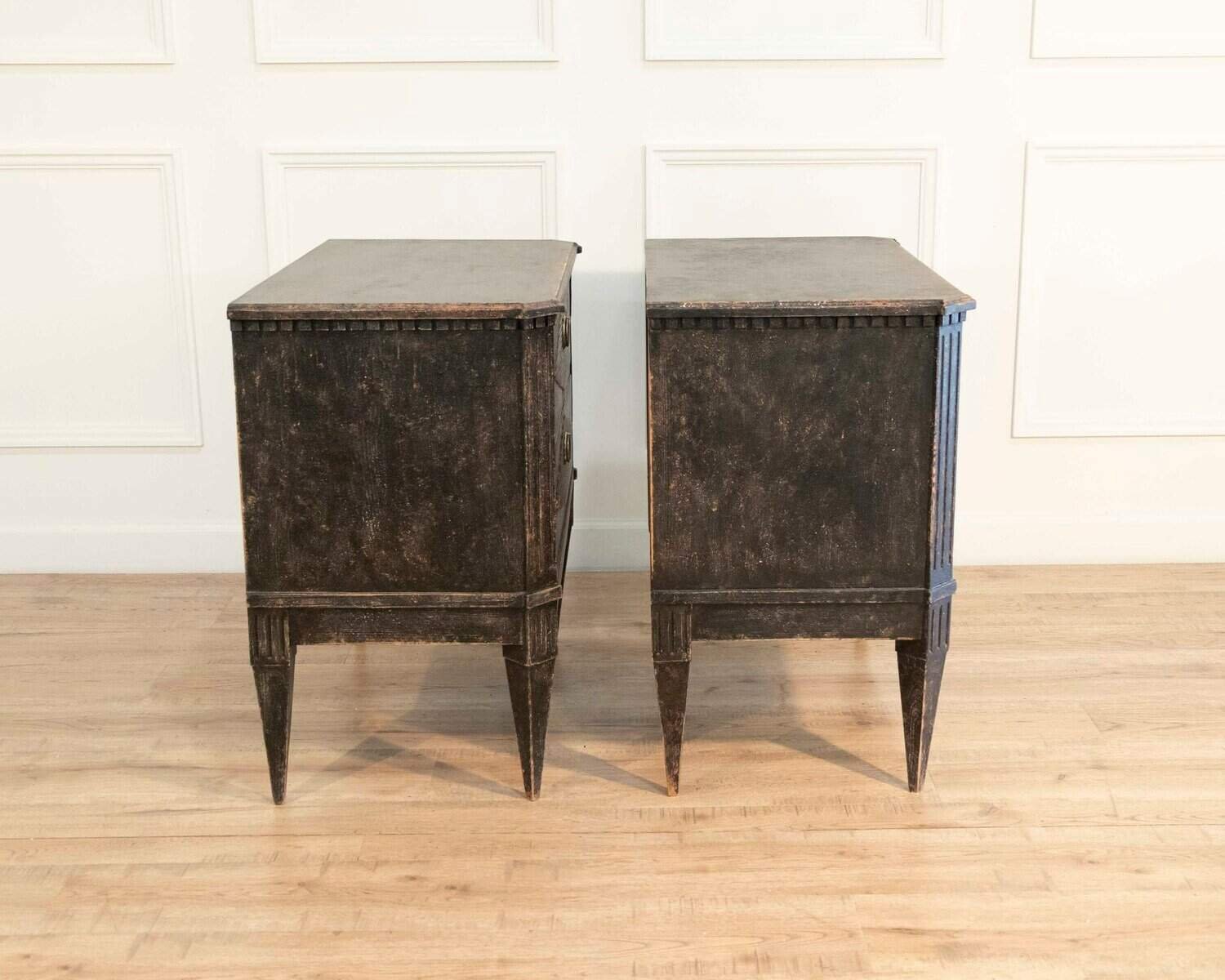 A pair of black Gustavian-style chests of drawers. - JAA