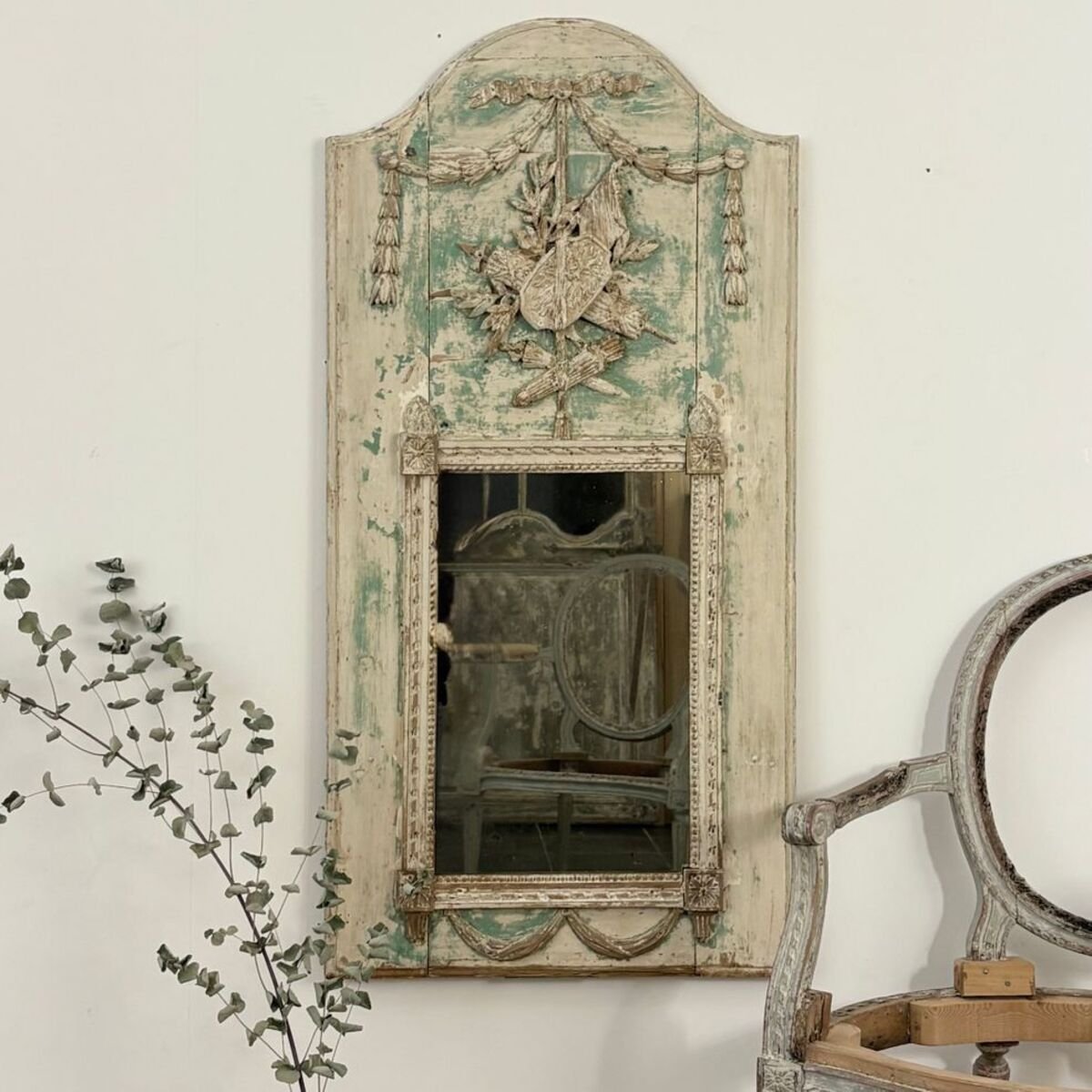 Superb small Louis XVI period trumeau mirror in carved wood decorated with warrior attributes, originally painted. - JAA