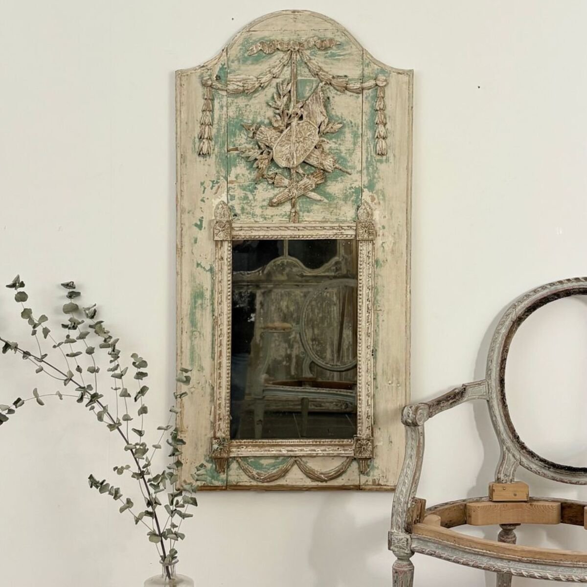 Superb small Louis XVI period trumeau mirror in carved wood decorated with warrior attributes, originally painted. - JAA
